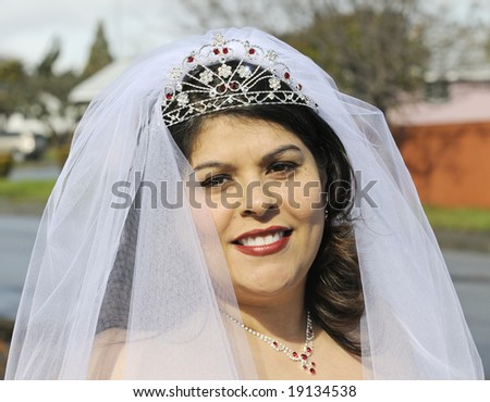 Beautiful smiling Hispanic Bride in veil and tiara before wedding