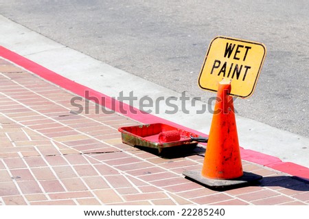 Traffic cone and wet paint sign