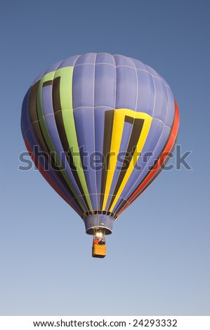 colorful balloon rising at dawn in the cold air at the Taos hot air balloon festival