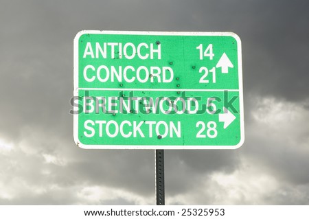Road sign with several bullet holes