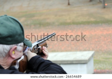 Trap shooter taking aim on a clay bird