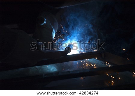 Blacksmith working on decorative handrail using a welder