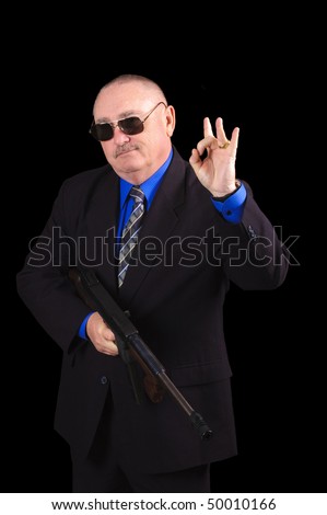 Gangster or Government agent, FBI agent, with a machine-gun and giving the OK sign, over a black background