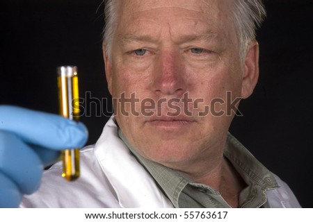 chemical engineer, doctor or research scientist looking at a sample of a chemical in a test tube