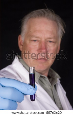 chemical engineer, doctor or research scientist looking at a sample of a chemical in a test tube