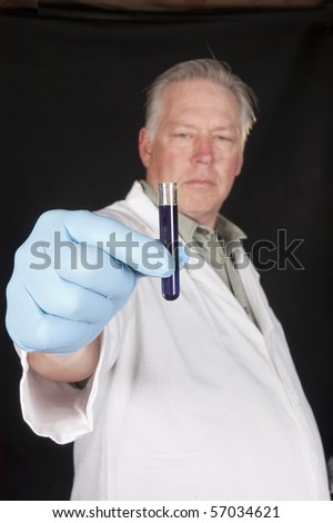 chemical engineer, doctor or research scientist using a pipette to take a sample of a chemical from a test tube