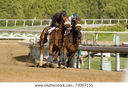Pair of jockeys training horses on track in preparation for race