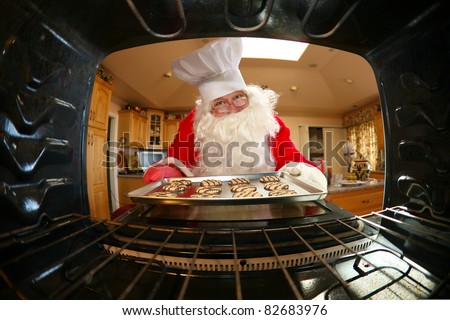 humorous image from within an oven of Santa in kitchen whipping up a batch of cookies,