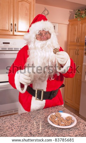 Santa pouring and drinking a glass of milk left out for him along with some cookies