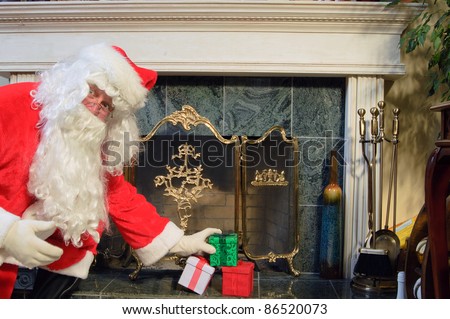 Santa placing some presents on the hearth looking surprised as he is caught doing it