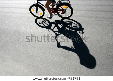 child on  a bicycle with his shade on the road bike race in denmark, cyclist are passing by a bike sign on the road. Shot with low shutter speed to achieve motion blur