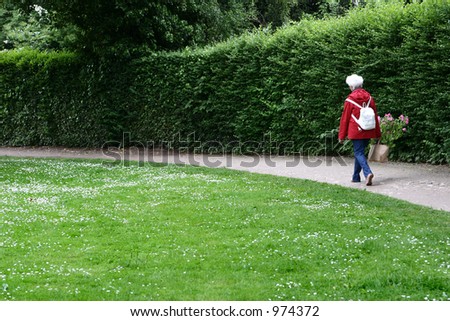 old lady with flowers in red in a park