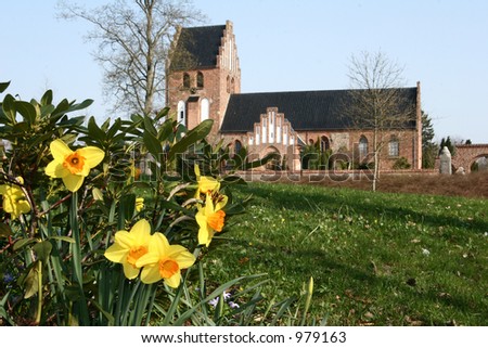 church  in denmark a sunny summer day with flowers in the foreground (focus in on flowers)