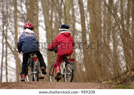 2 children with  bicycle in a forest man and  child in a forest
