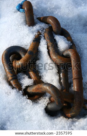 chain on a harbor in the snow a sunny cold day