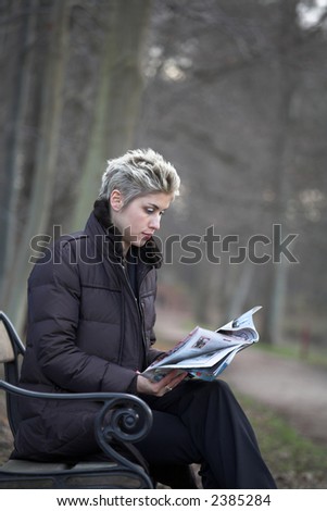 business woman outdoorin a park reading mails and notebook