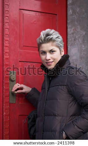 woman outdoor in a city on shopping tour,looking at the camera at a house door