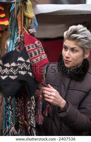 woman outdoor in a city on shopping tour, at the hat market