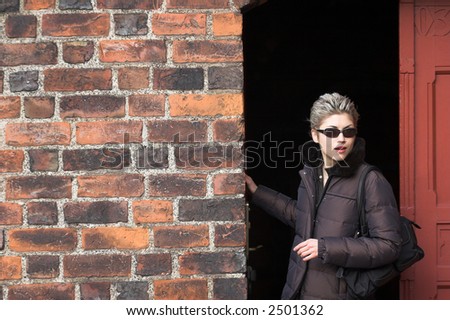 pretty woman outdoor in an old village in denmark with a wall   in red brick