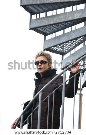 pretty woman outdoor on a metal staircase (fire emergency exit)
