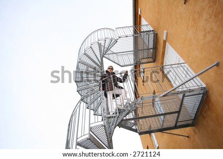 pretty woman outdoor on a metal staircase (fire emergency exit)