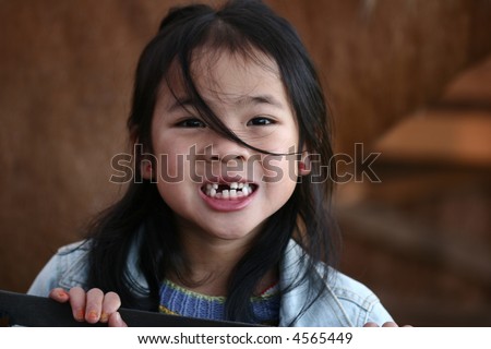 cute  chinese child portrait smiling with some missing tooth