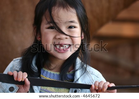 cute  chinese child portrait smiling with some missing tooth