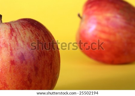 Picture of two apples with yellow background
