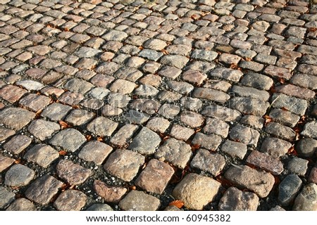 not created abstractions, curves, lines, patterns; cobble stones  street in the sun