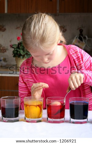Little girl coloring easter eggs