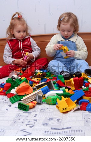 Two little girls playing with colorful cube blocks