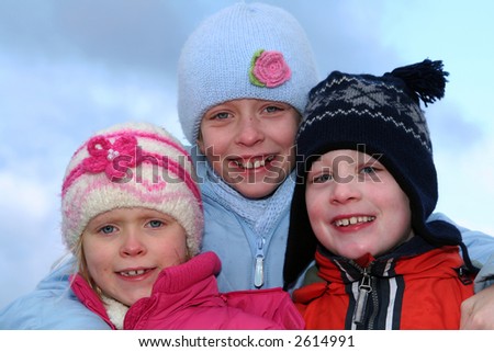 Happy children in winter outfit  on a blue sky background.