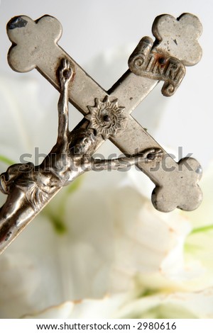 Old cross on white easter lilies background