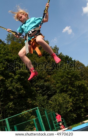Little blond girl on a mini bungee jumping