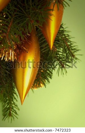 Golden decorations and spruce on a green background