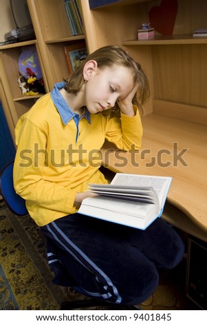 Young girl wearing yellow blouse sitting at the desk
