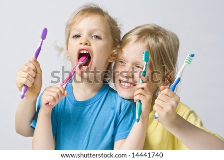 Little girl wearing colorful t-shirts brushing teeth