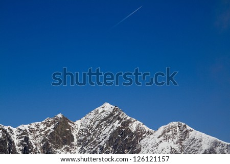 wake of a plane on the alps in winter