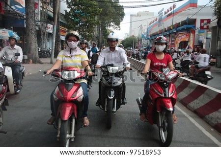 HO CHI MINH CITY VIETNAM - AUGUST 19: unidentified men and women rides motorbikes, on August 19, 2011, in Ho Chi Minh City, Vietnam. Ho Chi Minh City, also named Saigon, is the largest city in Vietnam