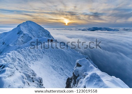 sunset over the mountains and clouds in winter. Piatra Craiului Mountains, Romania