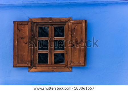 a small wooden window in a blue house