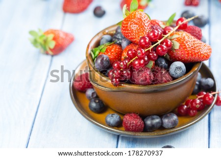tasty summer fruits on a wooden table. Cherry, Blue berries, strawberry, raspberries, Blackberries, pomegranate