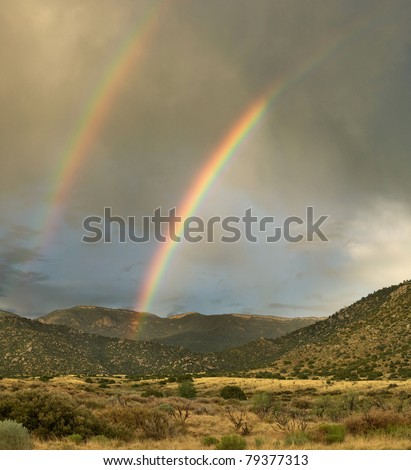 A double rainbow appears over Albuquerque\'s Sandia Mountains during the monsoon season