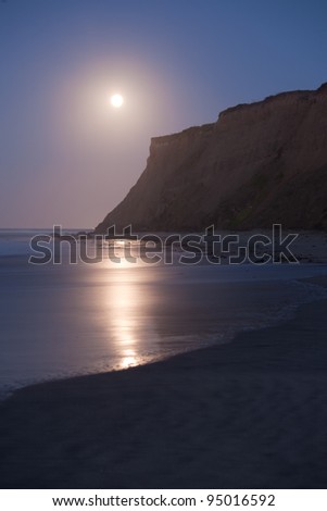 The moon setting at sunrise at Half Moon Bay, California