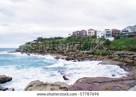 A view of the huge surf, cliffs and luxury housing at one end of famous Bondi Beach, New South Wales, Australia