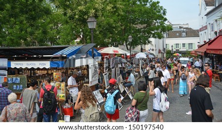 PARIS, FRANCE - JULY 24, 2013: Visitors at an art market in the district of Monmatre on July 24, 2013 in Paris.