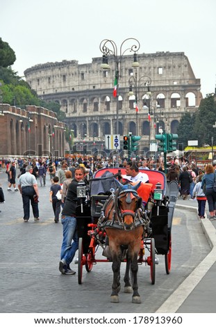 ROME, ITALY - APRIL 11, 2011: Crowds outside the Colosseum in the week before the Easter holiday. A horse and carriage in the foreground take tourists on guided tours of Rome.