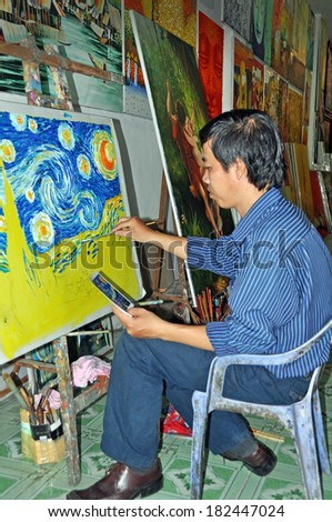 HO CHI MINH CITY, VIETNAM - JUNE 08, 2011: Young artist paints Van Gogh reproduction in a Saigon art Market.