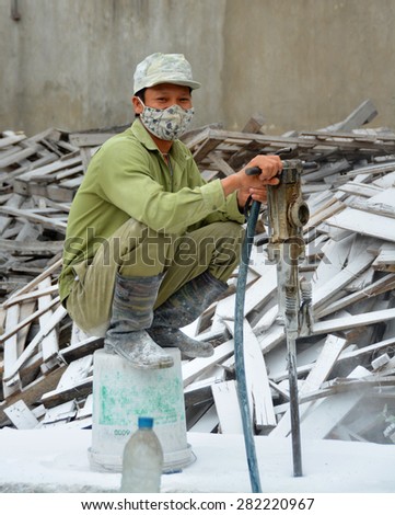 Ha Long Bay, Vietnam - April 17, 2015: Young man man working in a Ceramics factory in Ha Long Bay Vietnam surrounded by white Marble dust.