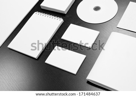 Blank stationery set on black wood background / business cards, letterheads, disk, envelope, booklet, notepad